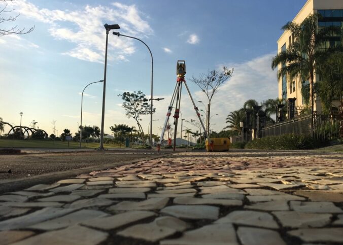 Estação total em tripé utilizada na locação de equipamentos de topografia para levantamentos em área urbana.